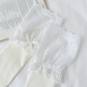 Detailed close-up view of white lace Lolita long slouch socks with sweet bowknot trim.