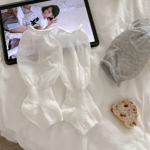 Vue détaillée de jambières blanches transparentes à poignets bouffants et tissu doux.
