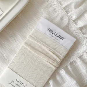 Close-up detail of hollow-out knit modal mid-calf socks with delicate lace trim design.