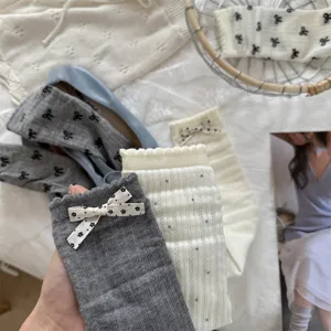 Primer plano de calcetines de media caña transpirables para mujer con lazo y lunares.