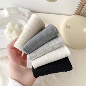 Close-up detail of women's casual cotton crew socks in multiple solid colors, soft texture.