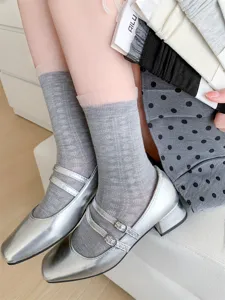 Close-up detail of women hollow lace socks paired with silver Mary Jane flats showing style.
