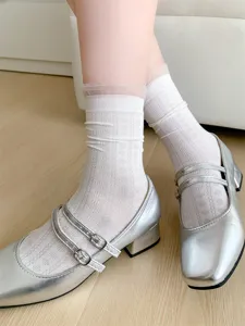 Detail shot of white hollow cotton lace-trim mid-tube socks paired with silver shoes.