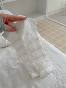 Detail shot of white ballet style thin stirrup leg warmers featuring delicate ruffle texture.