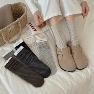 Close-up detail of soft cotton striped mid-tube slouch socks in neutral tones, lifestyle setting.