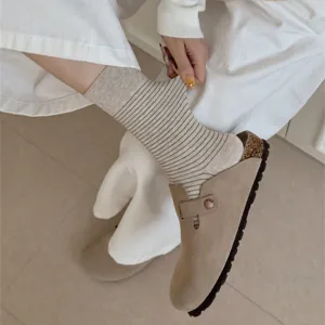 Detail shot of women's beige fine striped cotton mid-calf casual socks worn with clogs.