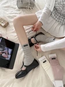 Detail shot of women's ballet style stirrup socks and leg warmers with ribbed design and label.