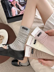 Detailed close-up of ribbed stirrup leg warmers and stackable socks in multiple soft colors.