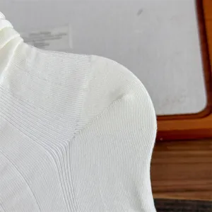 White ribbed knit sock detail close-up, showing soft textured fabric and elastic knit pattern.