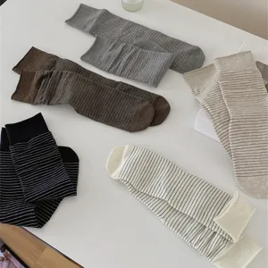 Close-up detail of womens basic striped cotton mid-tube socks in multiple soft colors, flat lay.