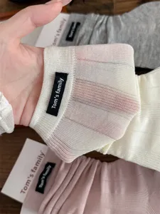 Detail view of women's sheer ribbed leg warmers, featuring soft breathable texture and brand label.
