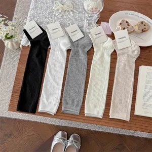 Detailed shot of thin ribbed stirrup socks and leg warmers in various neutral colors.