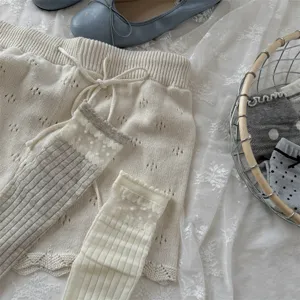 Detailed close up shot of spring summer women knit shorts and sheer lace ruffle slouchy socks.