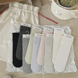 Detail view of casual solid color cotton mid-calf socks with cute ruffle cuffs and neat tags.