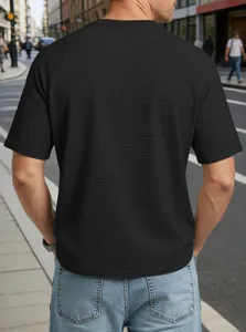 Close-up detail of mens black waffle knit short sleeve t-shirt with raglan sleeves texture.