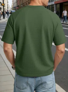 Detail shot of men's green waffle knit short sleeve t-shirt with raglan sleeves and casual style.
