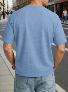 Back view detail of men's casual light blue waffle knit raglan short sleeve t-shirt outdoors.