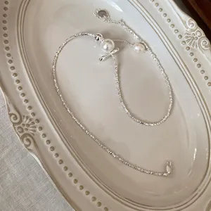Gedetailleerde close-up van een vintage zilveren getextureerde ketting met delicate parels.