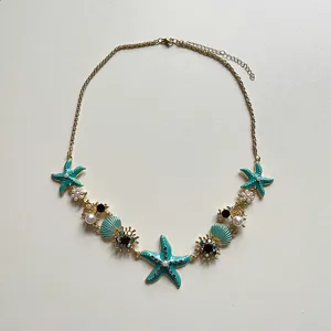 Exquisite detail of the coastal starfish and seashell necklace featuring pearls and sparkling rhinestones.