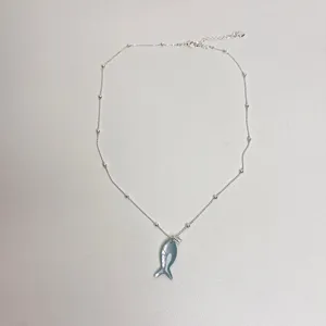 Nahaufnahme der silbernen Fischkette mit feinen Perlendetails und funkelndem Zirkon.