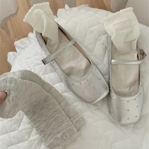 Detail shot of silver studded Mary Jane shoes paired with cute ruffled white and grey socks.