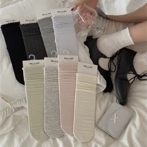 Detailed view of women's solid color modal cotton mid-calf slouch socks with delicate lace trim.