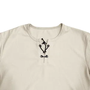 Détail en gros plan d'un t-shirt à manches courtes gaufré beige avec un col lacé élégant.