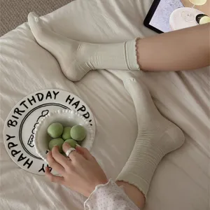 Detail shot of solid color ruffle mid-tube stacking socks, soft modal cotton material.