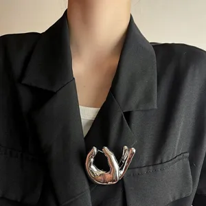 Chic metallic hand gesture brooch pin for women, stylish silver lapel accessory for suits.