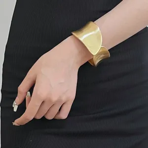 Wide gold cuff bracelet for women, open design statement bangle jewelry for summer fashion wear.