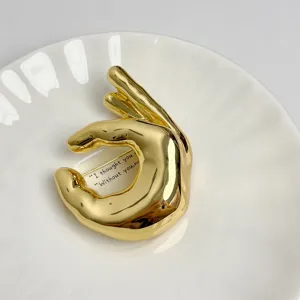 Gold metal OK hand sign brooch detail, chic minimalist fashion accessory pin for clothes.