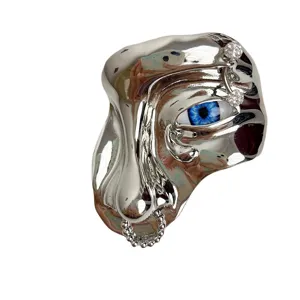 Surreaal zilveren metalen gezicht broche met blauw oog en strass sten. Uniek.