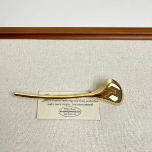 Gold abstract metal brooch for women, elegant minimalist design for sweaters and coats.