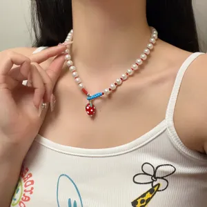 Gedetailleerde close-up van een schattige aardbei parelketting, zoete hanger sieraden voor dagelijks.