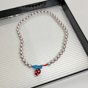 Detailopname van de schattige aardbeien parelketting met rode en witte kralen voor jou.