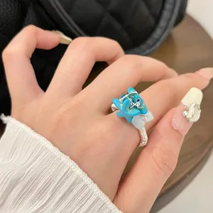 Closeup of handmade wire wrapped natural blue stone ring showcasing intricate craftsmanship.