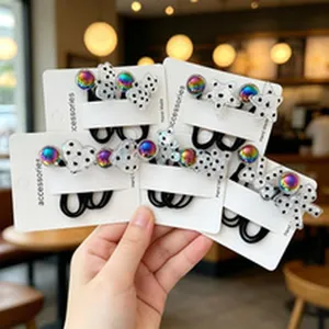Detailed view of polka dot hair ties with iridescent rainbow beads on display cards
