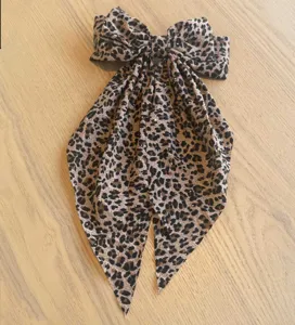 Eleganter Haarclip mit Leopardenmuster, glitzernden Strasssteinen und langen Luftschlangen.