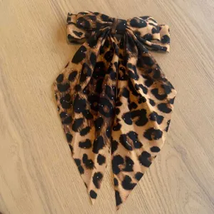 Eleganter Haarclip mit Leopardenmuster-Schleife, langen Bändern und kleinen Strasssteinen.