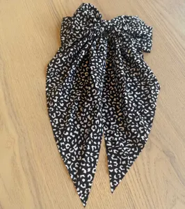 Nahaufnahme einer Vintage-Haarspange mit schwarz-weißer Leoparden-Schleife und Bändern