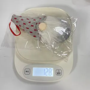 Ornement de gnome de Noël tricoté pesant 12,8 g sur une balance