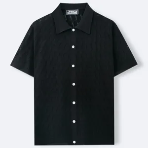 Vista dettagliata della polo nera in maglia a maniche corte con motivo jacquard