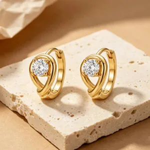Close-up of elegant gold-finished hoop earrings featuring a sparkling round zircon