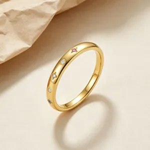 Close-up detail of an elegant gold-plated silver ring with colorful zircon star insets
