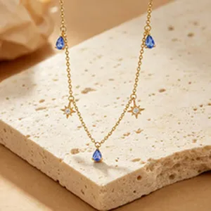 Close-up of gold s925 silver necklace with blue teardrop zircons and stars