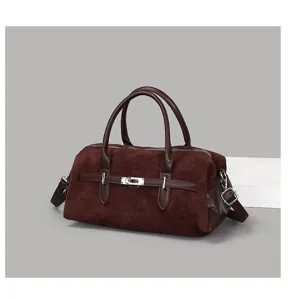 Détail du sac Boston en daim bordeaux vintage avec bride à boucle en cuir classique