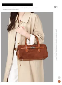 Sac Boston vintage en daim marron avec boucle de ceinture porté par un mannequin