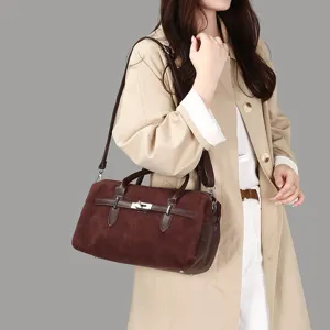 Sac Boston rétro élégant en daim marron avec boucle de ceinture porté par un mannequin