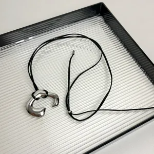 Minimalist irregular metallic pendant black leather cord necklace for women chic daily jewelry.
