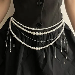 Detailaufnahme der mehrschichtigen Perlen-Taillenkette mit zarten Metallquasten und Perlen.